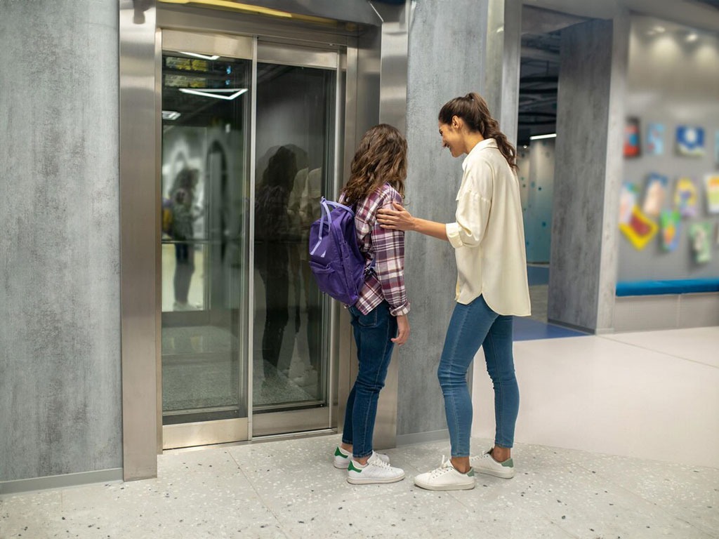 Mare i filla utilitzant un ascensor modern