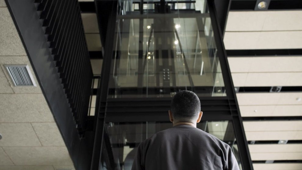 Persona observant un ascensor panoràmic