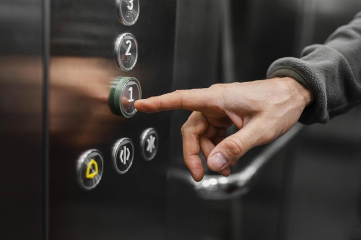Detall de mà prement botons d'ascensor